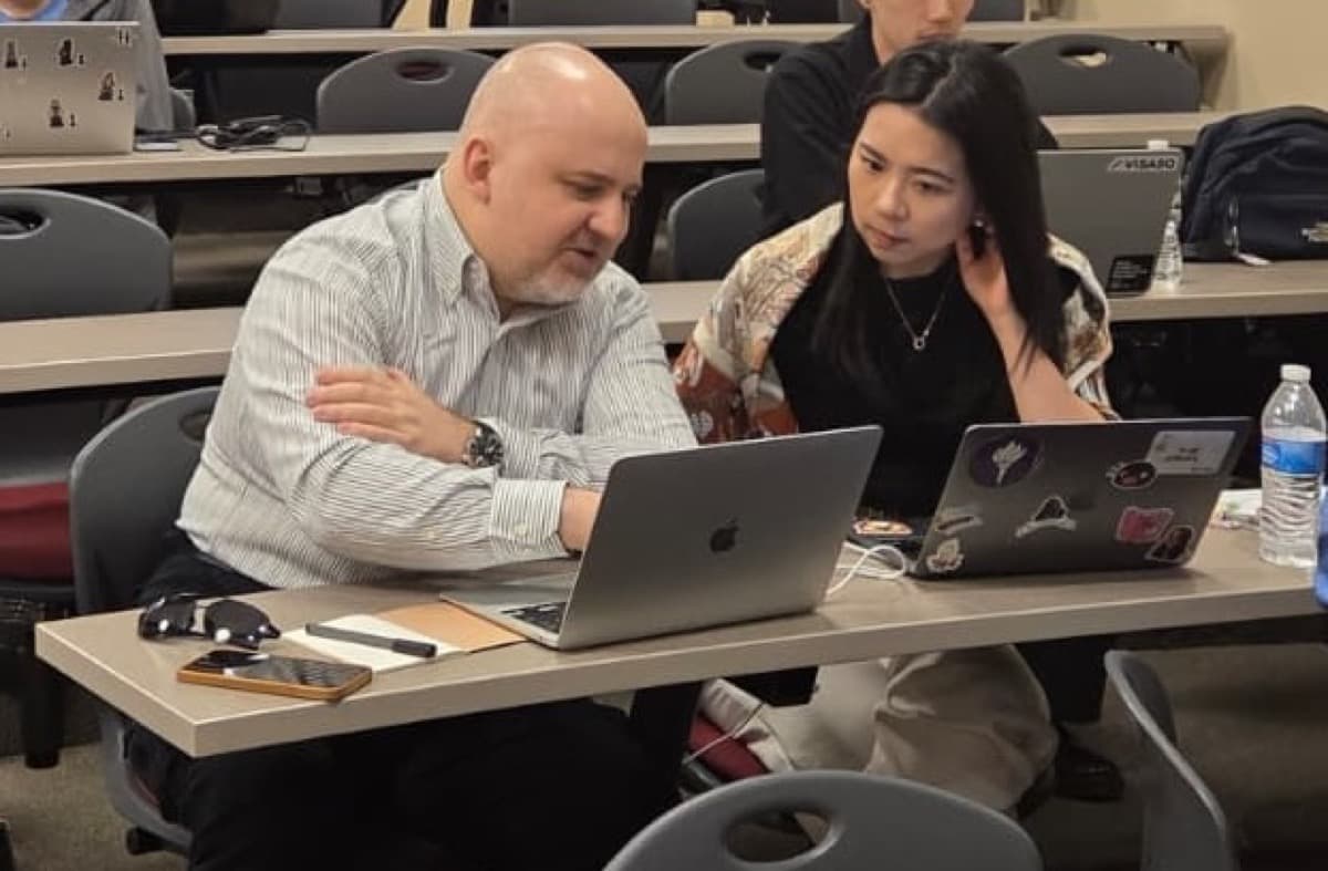 Two attendees comparing notes across a shared desk