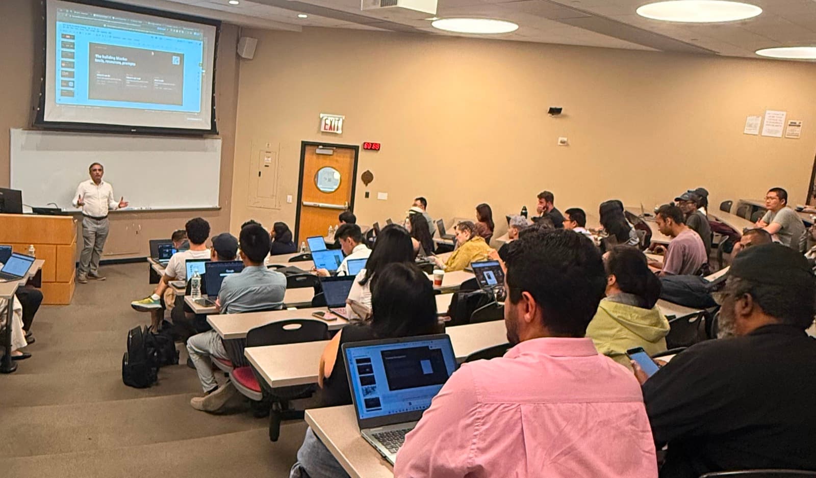 Wide view of the MCP workshop lecture hall, slides on the projector