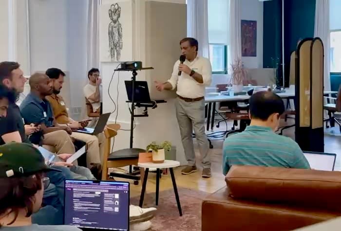 Dean Grover presenting to a seated audience in the DUMBO loft